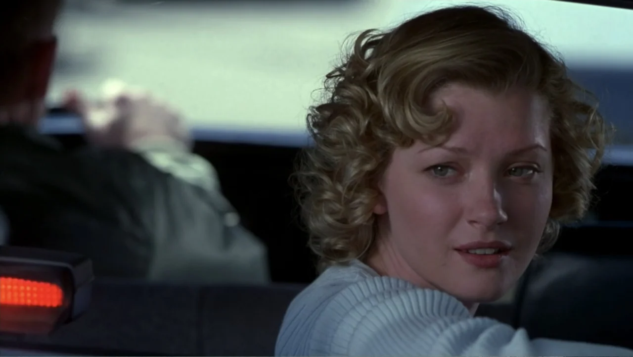 Music from Another Room (1998) movie still: medium — A woman sits in the front passenger seat of a vehicle during the day. She turns her head to…