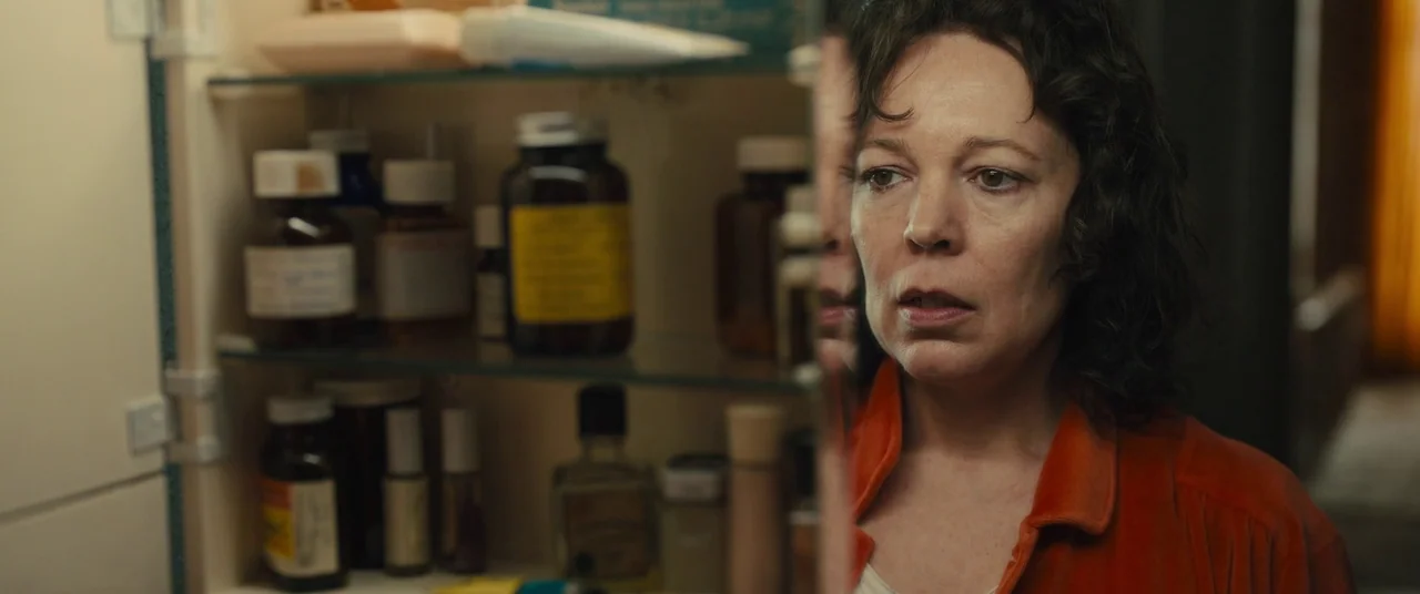 Empire of Light (2022) movie still: closeup — A bathroom interior features an open medicine cabinet filled with various brown glass pill bottles. A…