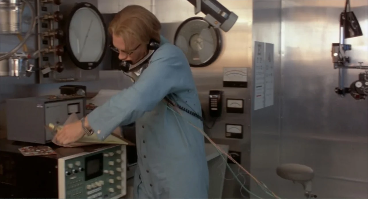 Making Mr. Right (1987) movie still: medium — A sterile laboratory setting featuring metallic wall panels, large circular pressure gauges, and…