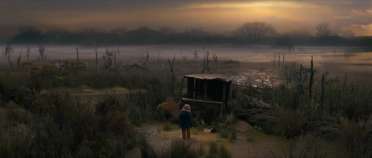 The Lovely Bones (2009) movie still: wide — A desolate, fog-covered marshland features dead trees and a small wooden structure at dusk. A young…