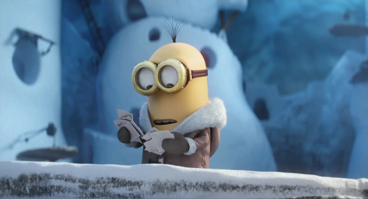 Minions (2015) movie still: medium — An arctic landscape covered in snow with a large white structure in the background. A small yellow creature…
