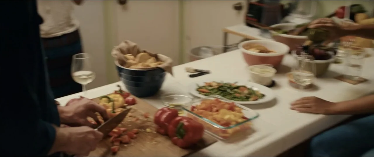 Plus One (2019) movie still: medium — A well-lit kitchen counter contains several bowls of fresh vegetables and cooking ingredients. One person…