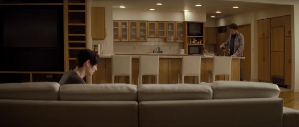 We Need To Talk About Kevin (2011) movie still: wide — A spacious home interior features an open-concept layout with light-colored cabinets and…