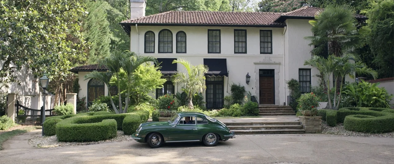 Father of the Bride (1991) movie still: wide — A two-story white stucco mansion features a terracotta roof and well-manicured landscaping. A dark…