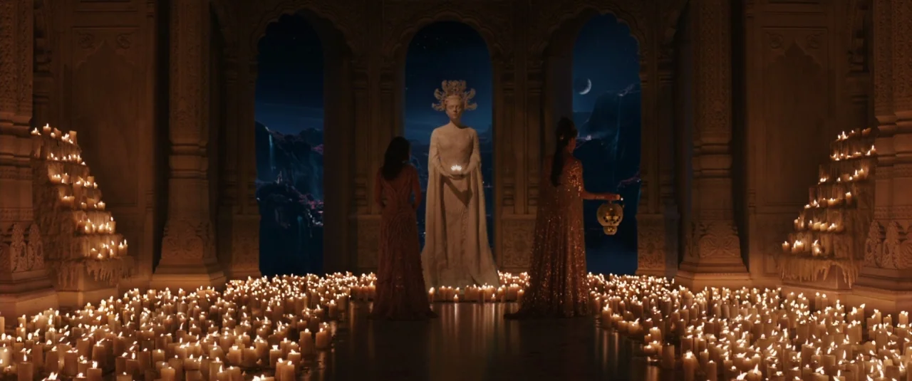 Jupiter Ascending (2015) movie still: wide — A dark stone temple interior is filled with hundreds of lit candles on floors. Two women stand in front…