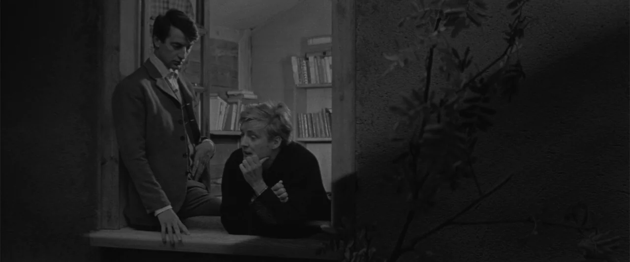 Jules and Jim (1962) movie still: medium — A dark wooden window frame connects an interior shelf to the exterior wall area. Two men in dark clothing…