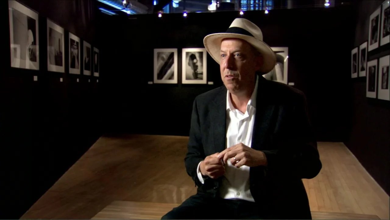 Dark Light: The Art of Blind Photographers (2009) movie still: medium — A dark, modern art gallery features multiple framed photographs displayed on…