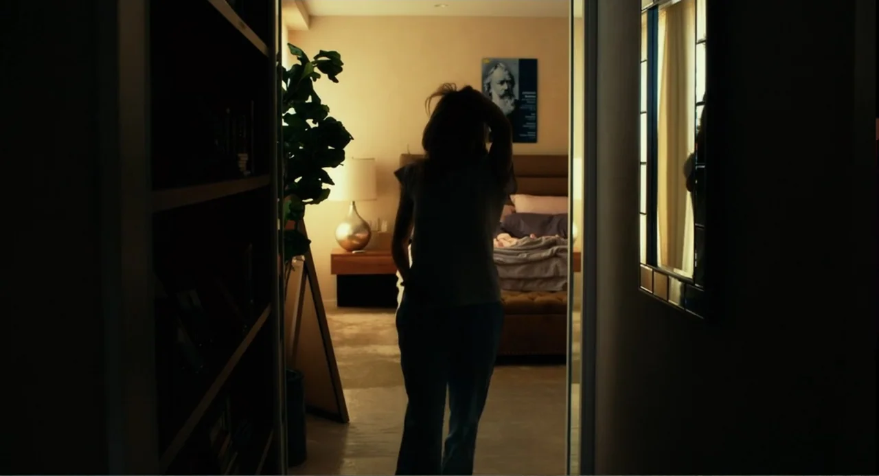 An Imperfect Murder (2017) movie still: medium — A dark, silhouetted figure stands in the threshold between a dimly lit hallway and a bedroom. The…