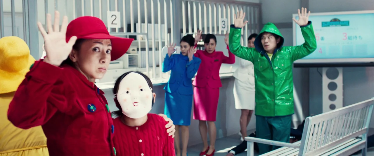 Prisoners of the Ghostland (2021) movie still: medium — A sterile bank lobby features white teller partitions and a digital queue display board.…