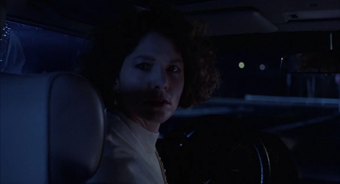 Creepshow 2 (1987) movie still: closeup — The interior of a vehicle at night with dark surroundings visible through the window. A woman with curly…