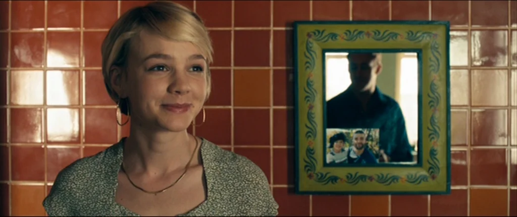 Drive (2011) movie still: medium — A bathroom wall is covered in square orange and rust-colored ceramic tiles. A woman stands in the foreground…