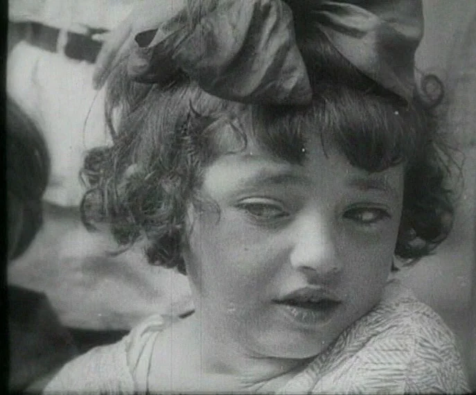 Man with a Movie Camera (1929) movie still: closeup — A young girl with a large hair bow is centered in a close-up shot. Her head is turned slightly…