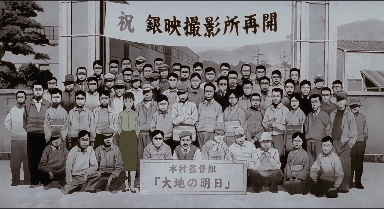 Millenium Actress (2001) movie still: fullbody — A large group of people stand for a commemorative photograph outside a studio building. A large…