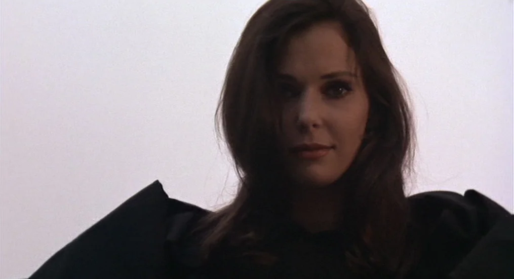 The Trip (1967) movie still: closeup — A woman is centered against a featureless, bright white sky. She gazes forward into the lens while wearing…