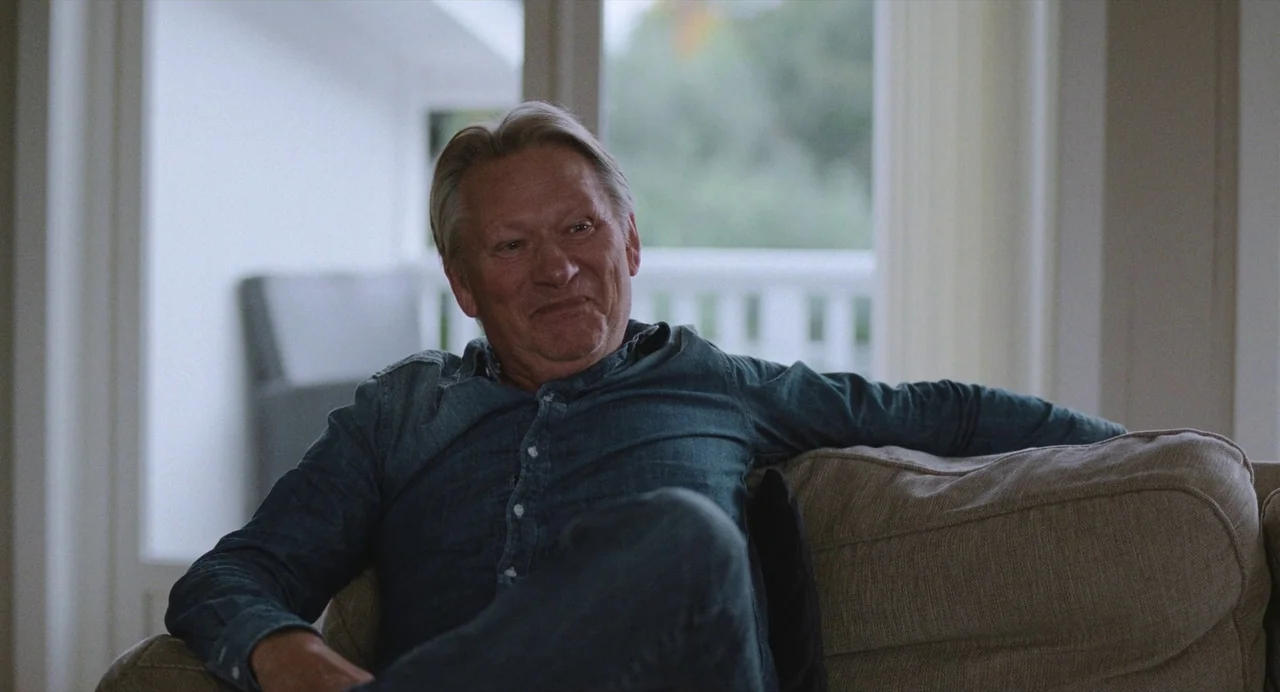 The Worst Person in the World (2021) movie still: medium — A bright living room features large glass doors opening to a blurry exterior view. An…
