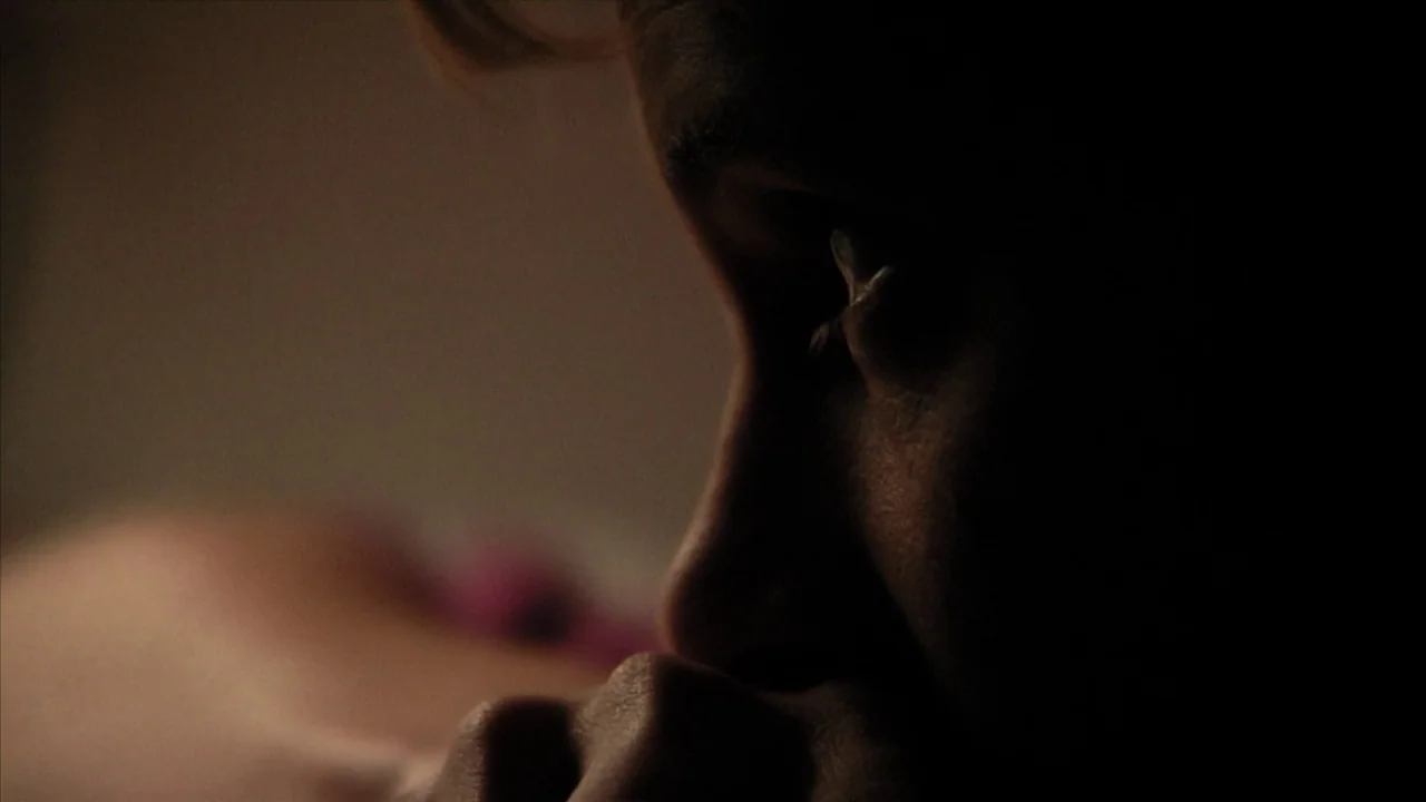 A Horrible Way To Die (2010) movie still: closeup — The frame shows a dark interior space with a person's face partially visible. The subject rests…