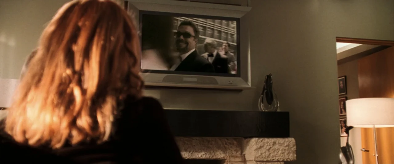 Charlie's Angels (2000) movie still: medium — An interior living room at night features a woman seen from behind watching TV. A television mounted…