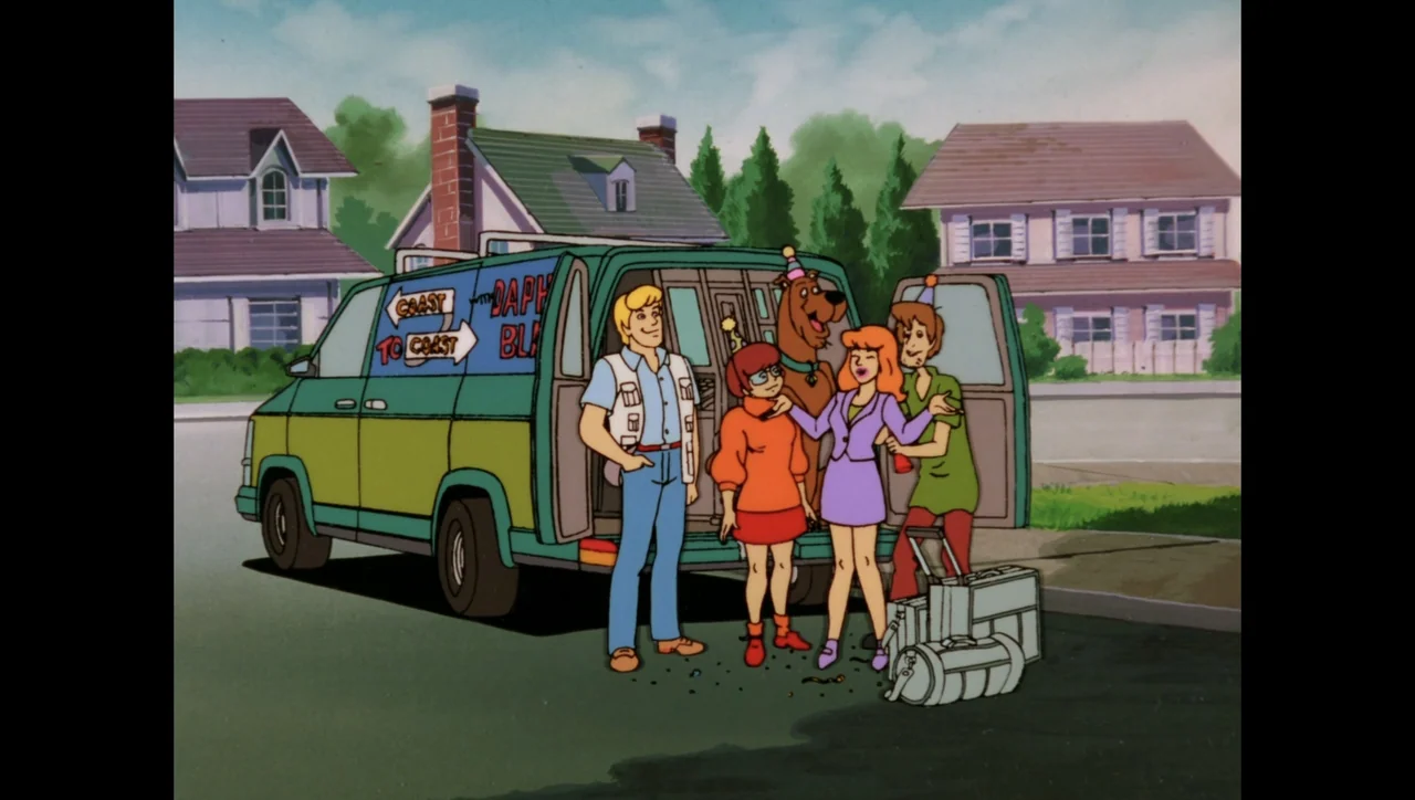 Scooby-Doo on Zombie Island (1998) movie still: fullbody — A cartoon suburban street features a brightly painted van parked near two houses. The…