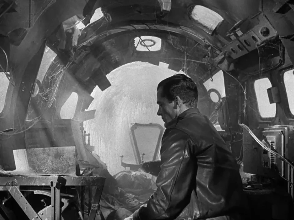 The Best Years of Our Lives (1946) movie still: medium — An abandoned, dusty aircraft nose section features dangling wires and cobwebs near the…
