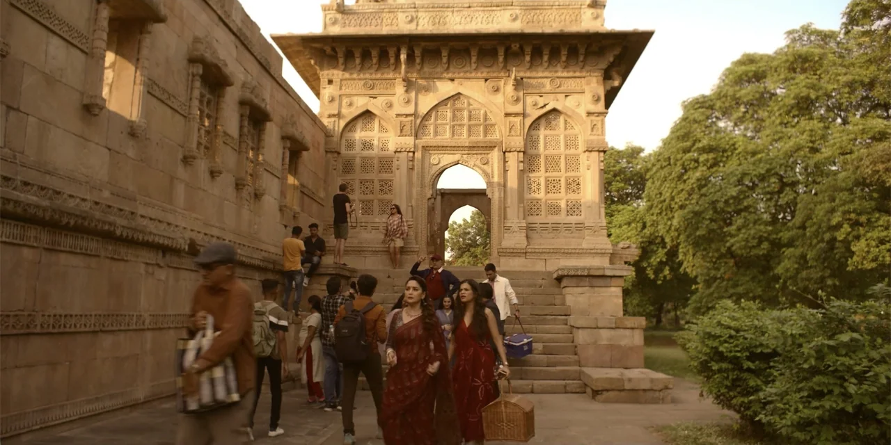 Maja Stoneface (1996) movie still: wide — A group of people gathers near ornate stone carvings of an ancient architectural structure. Two women in…