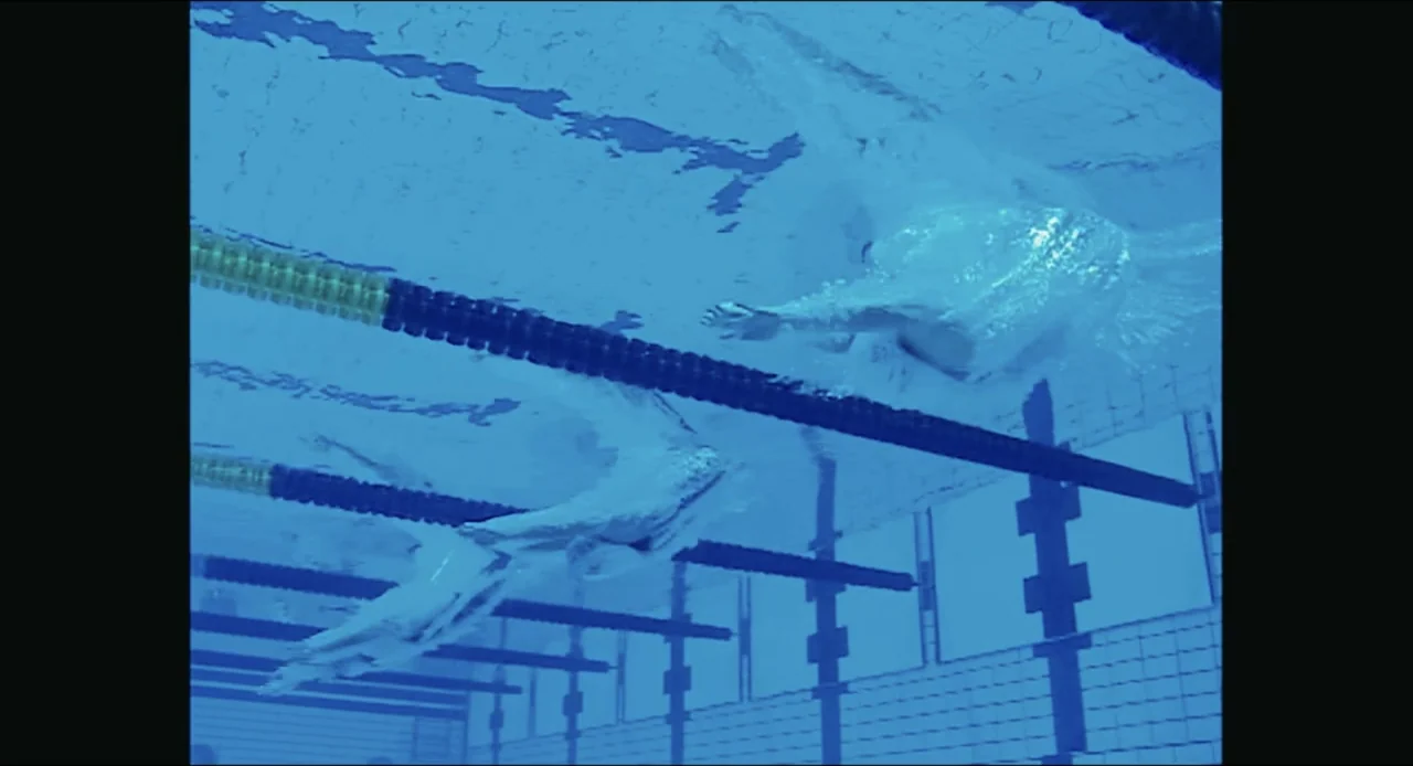 Federica Pellegrini - Underwater (2022) movie still: medium — An underwater perspective captures two swimmers moving through a clear chlorinated…