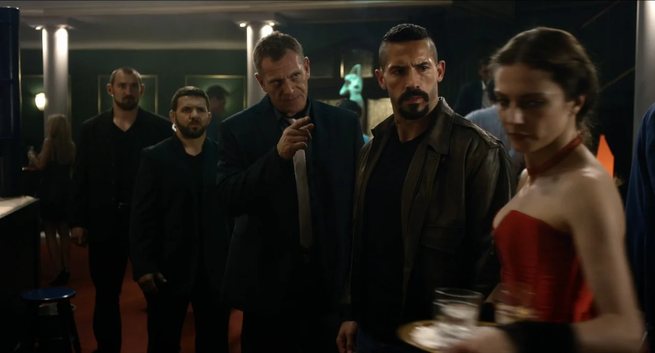 Boyka: Undisputed IV (2016) movie still: medium — A dimly lit indoor space with white columns and dark green walls. Three men stand in a group while…