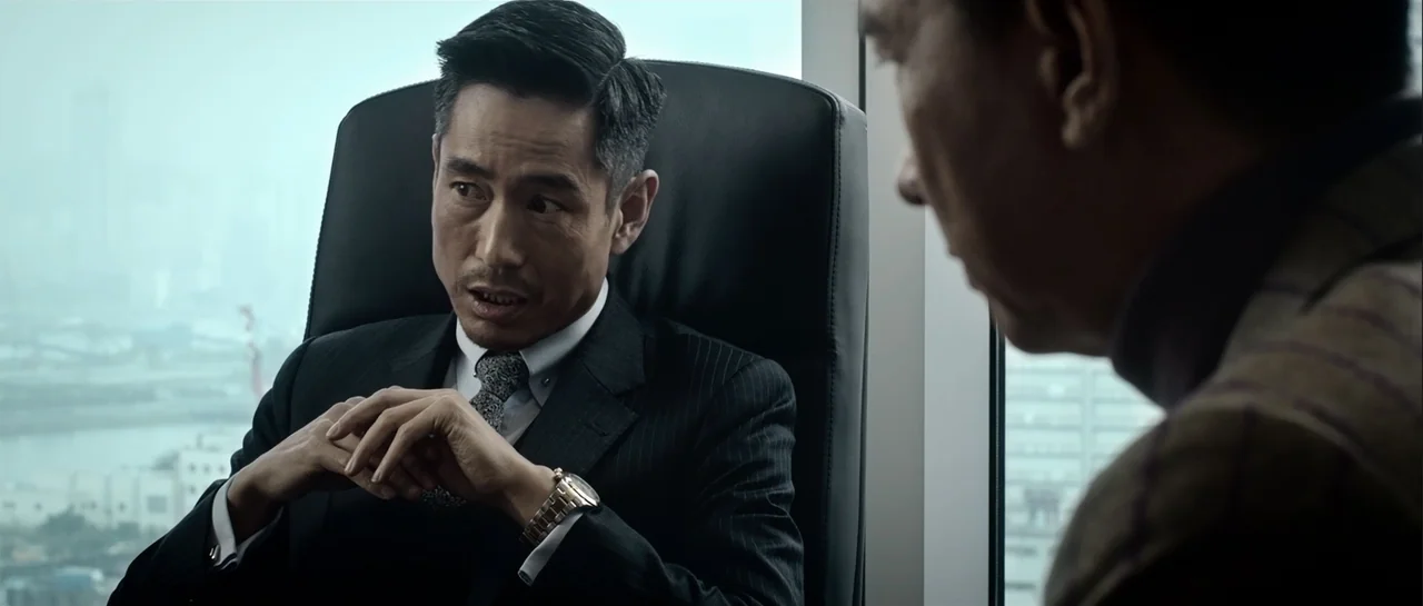 Line Walker (2016) movie still: medium — A high-rise office features large windows overlooking a city skyline on a cloudy day. An Asian man in a…