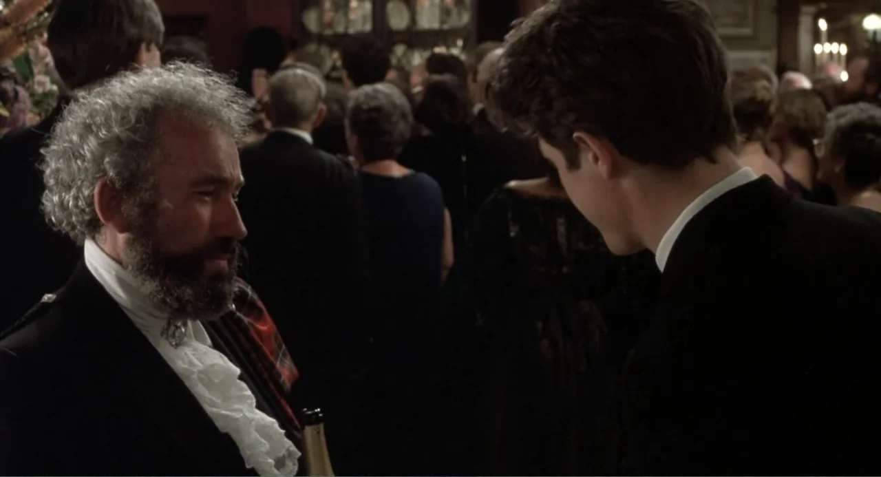 Four Weddings and a Funeral (1994) movie still: medium — A crowded formal event features people in evening wear gathered in a large room. An older…
