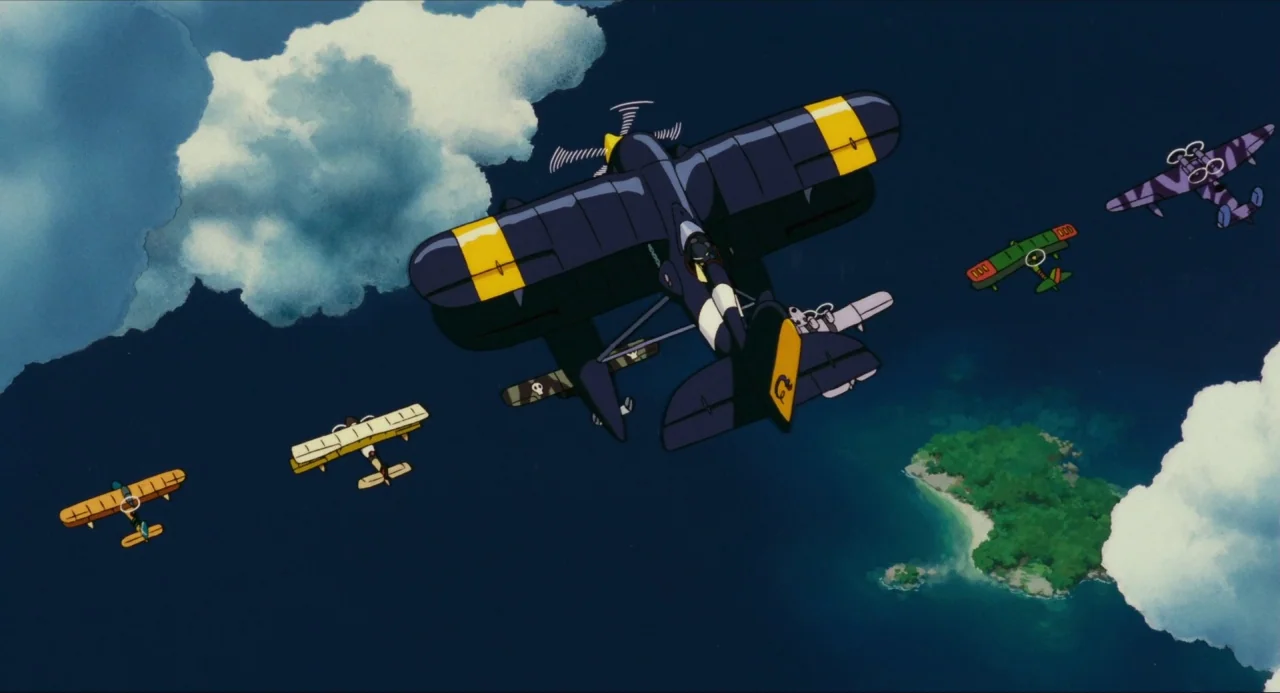 Porco Rosso (1992) movie still: wide — A dark blue sky filled with large, fluffy white clouds over a small island. A squadron of six colorful…