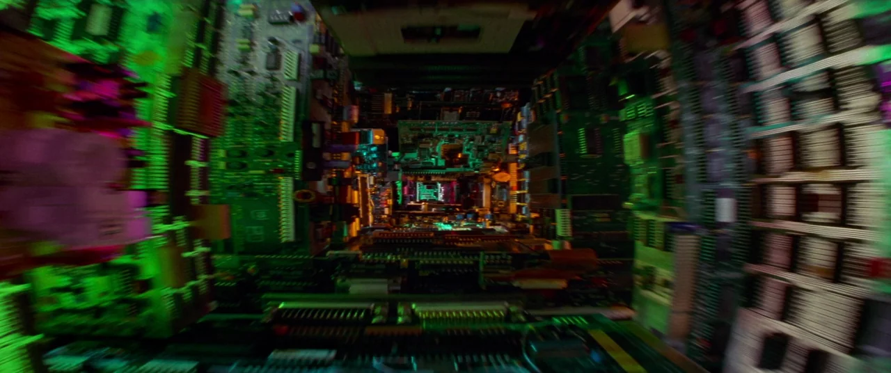 Hackers (1995) movie still: establishing — A miniature tunnel is constructed from stacks of dense computer circuit boards and components. The…