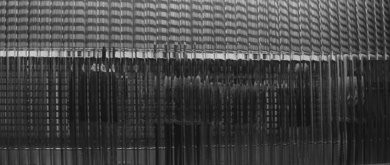 Ikarie XB 1 (1963) movie still: medium — A vertical fluted glass or metal wall creates a repetitive pattern of light and shadow. The surface texture…