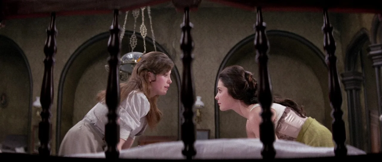 The House That Screamed (1969) movie still: medium — An dimly lit interior with arched architectural features and a dark wooden bed frame. Two women…