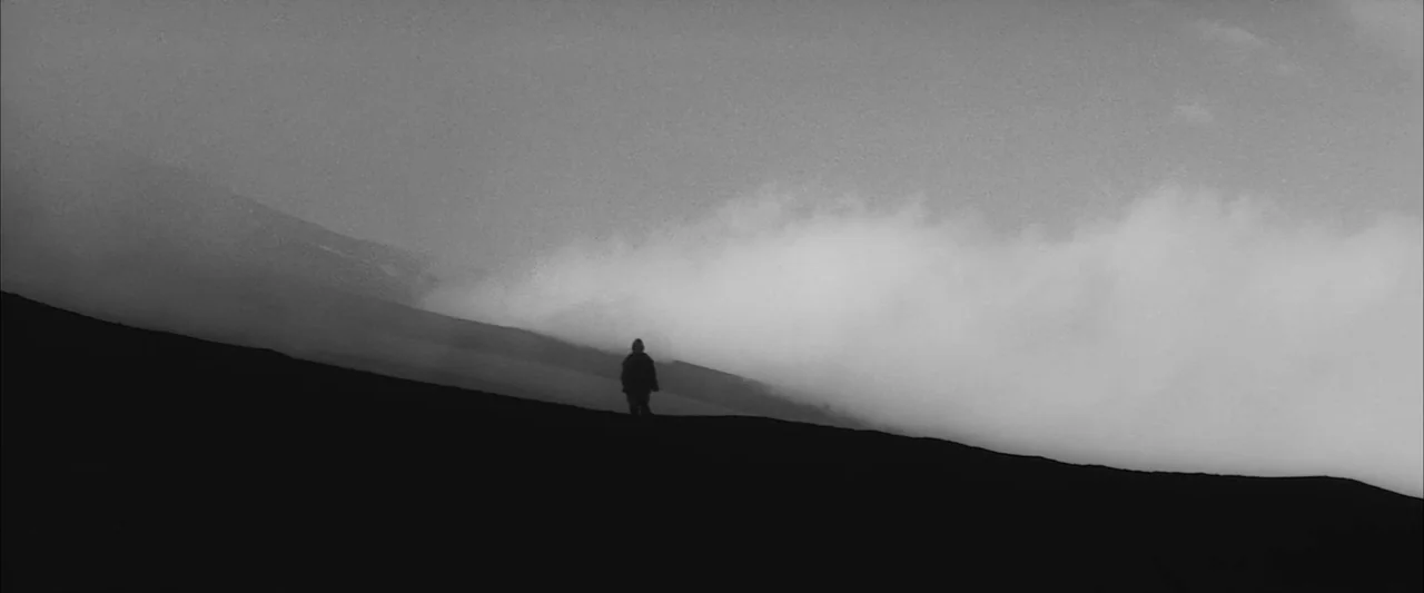 The Human Condition III: A Soldier’s Prayer (1961) movie still: wide — A dark, silhouetted human figure stands on the crest of a barren, foggy hill.…