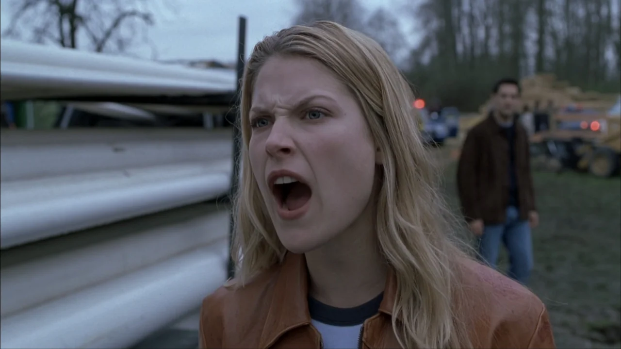 Final Destination 2 (2003) movie still: medium — An outdoor construction site features stacks of white pipes and a blurred background vehicle. A…