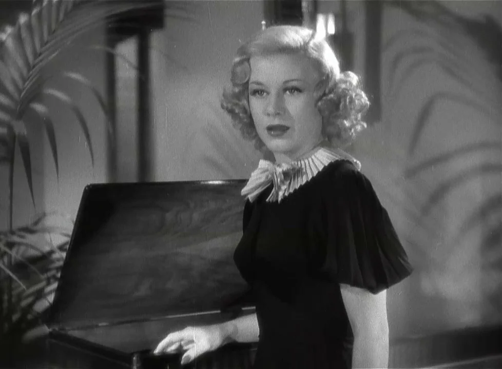 Swing Time (1936) movie still: medium — A woman stands in a domestic interior with palm leaf shadows cast against the wall. She touches the open lid…