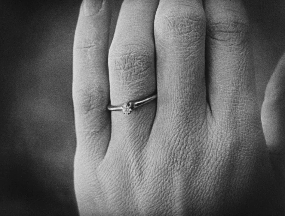 Sherlock Jr. (1924) movie still: closeup — A close-up view of a hand wearing a simple metal ring. The skin texture is visible and grain is prominent…