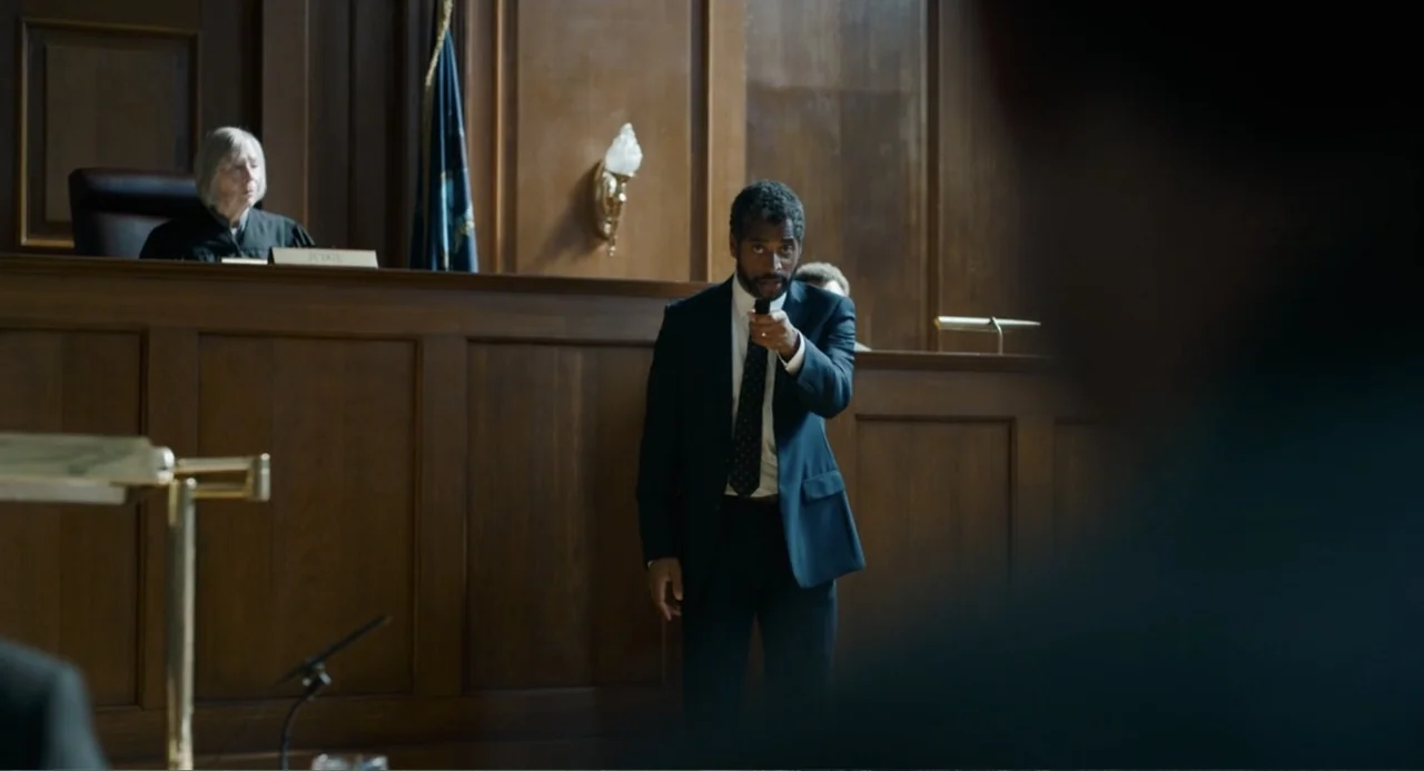 The Flash (2023) movie still: medium — A courtroom interior features dark wood paneling and a raised judge's bench. A man in a dark suit stands…