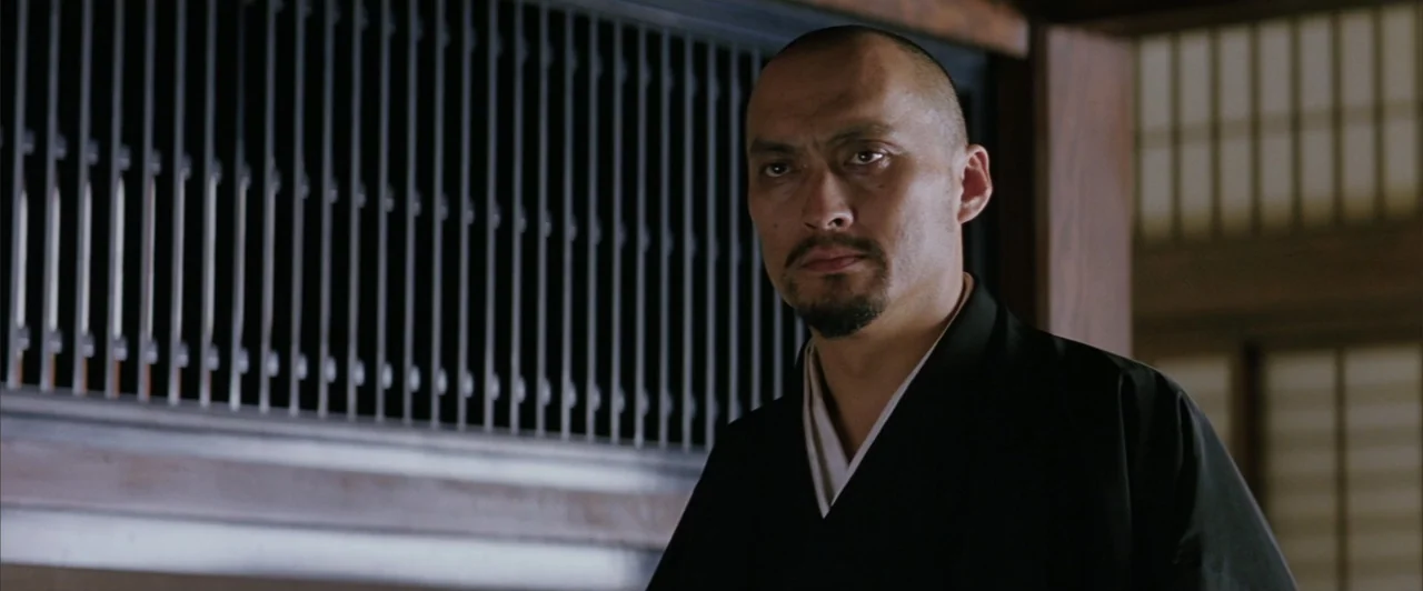 The Last Samurai (2003) movie still: medium — A Japanese room features dark wood trim and vertical shoji screen slats. A man stands in the…