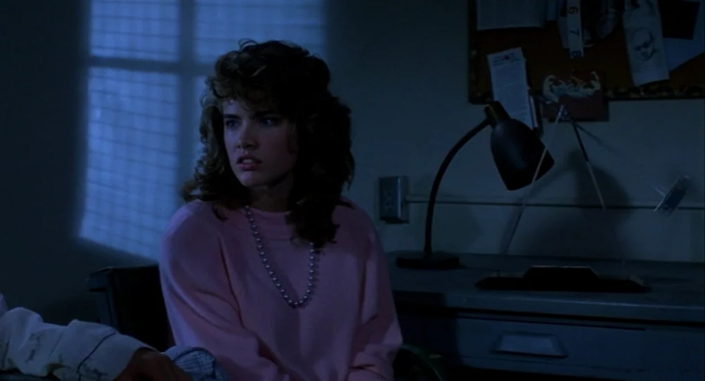 A Nightmare On Elm Street 3: Dream Warriors (1987) movie still: medium — A dimly lit room features a desk and a cork board with notes attached. A…