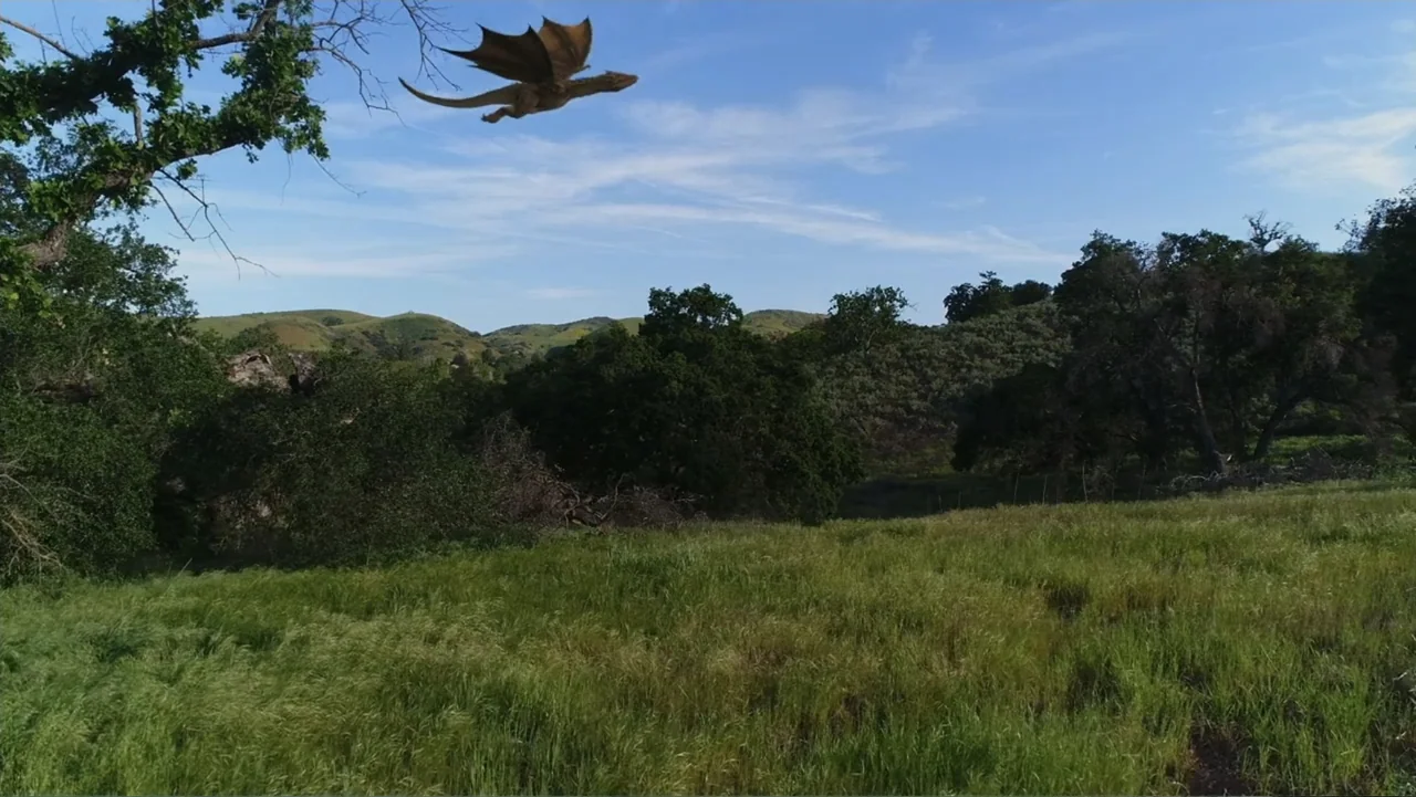 Empire Queen: The Golden Age of Magic (2024) movie still: wide — A vast green hillside stretches under a clear blue sky with distant low mountains.…