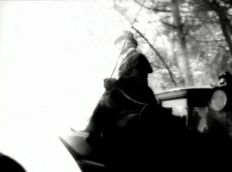 Cuadecuc, Vampir (1971) movie still: medium — A person sits atop a carriage while traveling through a tree-lined path. The bright sky creates a…