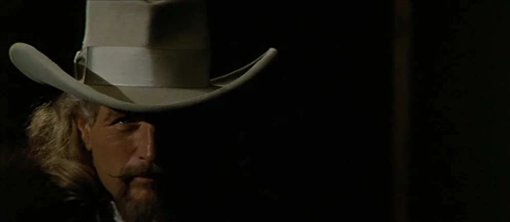 Buffalo Bill and the Indians, or Sitting Bull’s History Lesson (1976) movie still: closeup — The face of a man wearing a cowboy hat emerges from a…