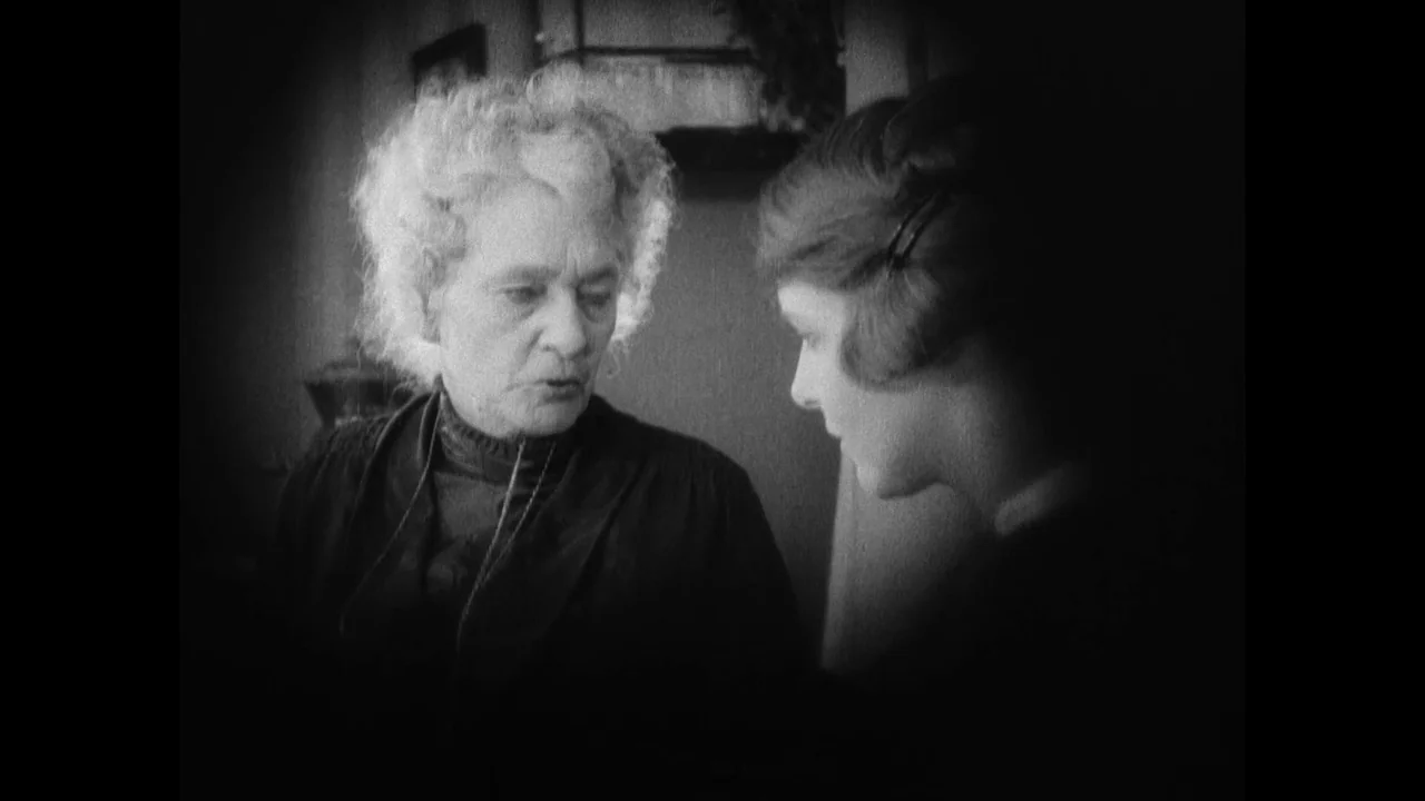 Master of the House (1925) movie still: medium — An interior space features two women in a dimly lit, high-contrast environment. An older woman with…