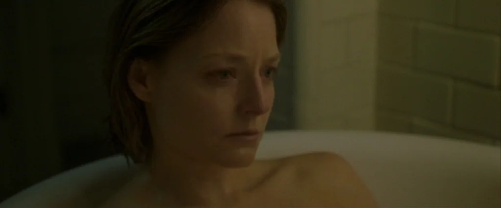 Panic Room (2002) movie still: closeup — A tiled interior wall sits behind a woman partially submerged in a white tub. The woman looks away from the…