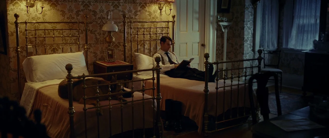 The Man Who Killed Hitler and Then the Bigfoot (2018) movie still: wide — A 1940s room features ornate floral wallpaper, two brass-framed beds, and…