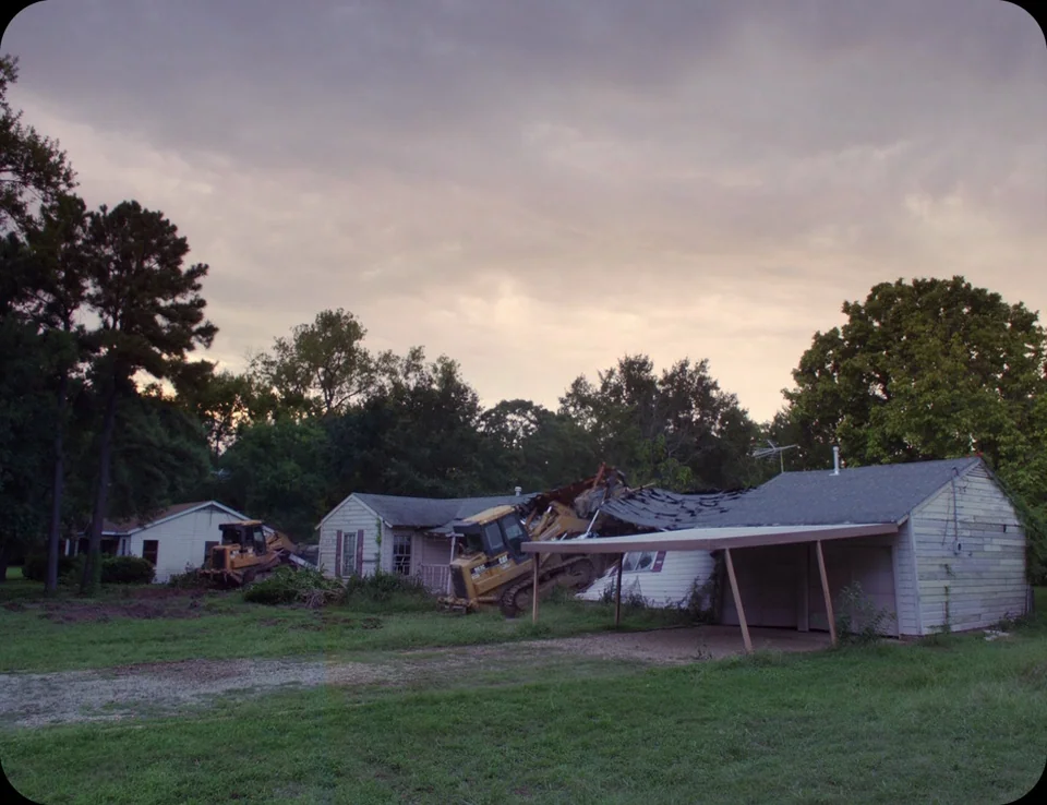 A Ghost Story (2017) movie still: wide — A single-story residential home is in the process of being demolished by heavy machinery. Two yellow…