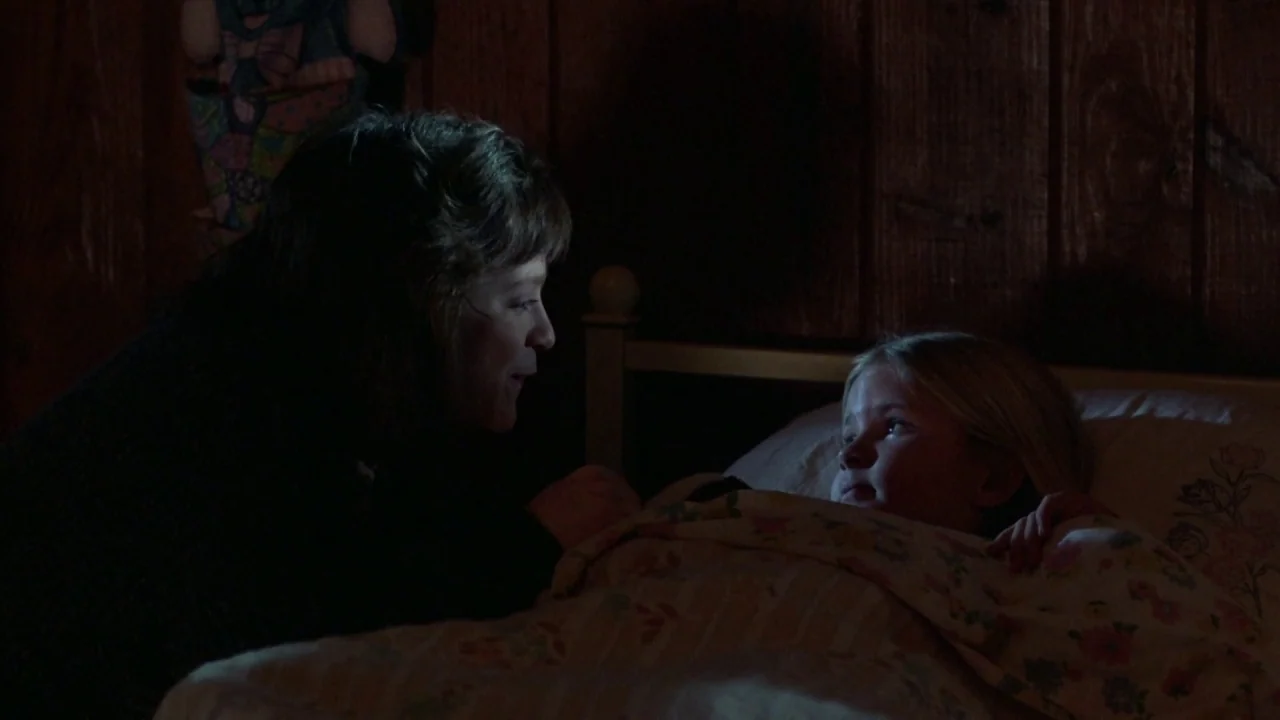 Friday the 13th Part VI: Jason Lives (1986) movie still: medium — A dimly lit room features wood-paneled walls and a bed with a floral duvet. A…