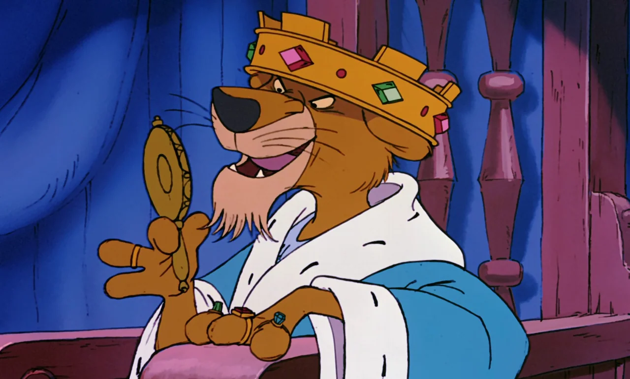 Robin Hood (1973) movie still: medium — An anthropomorphic lion king sits in a regal setting with blue curtains. He looks into a gold hand mirror…