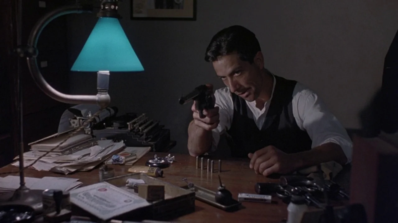 Matewan (1987) movie still: medium — A dark office features a mahogany desk cluttered with old documents and gun cleaning supplies. A man in a vest…