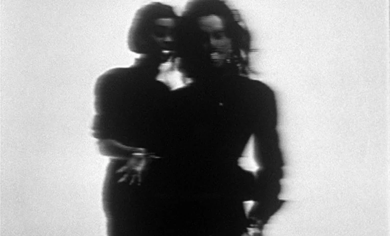 Paris Is Burning (1990) movie still: medium — A high-contrast black-and-white scene with two women posed against a bright white background. They…